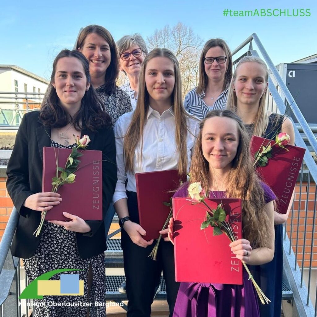 vier Absolventinnen halten ihr druckfrisches Abschlusszeugnis in den Händen, begleitet von Praxisberaterinnen und unserer Pflegedirektorin