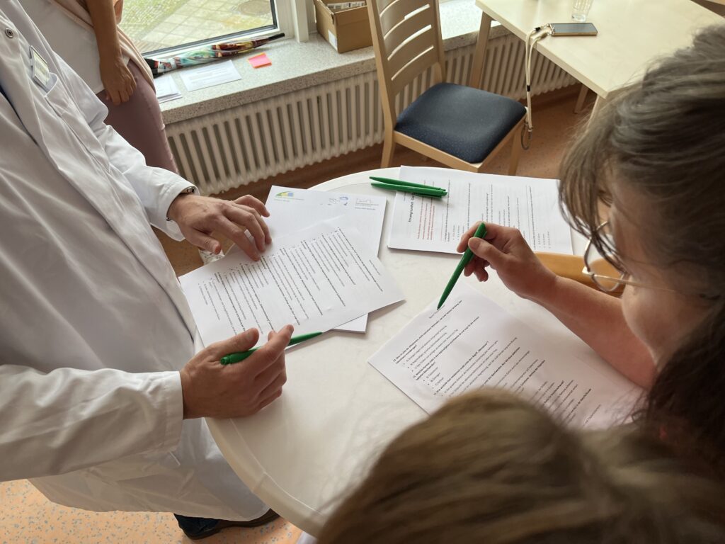 Interessierte Besucherinnen füllen ein Quiz der Klinik für Frauenheilkunde aus.