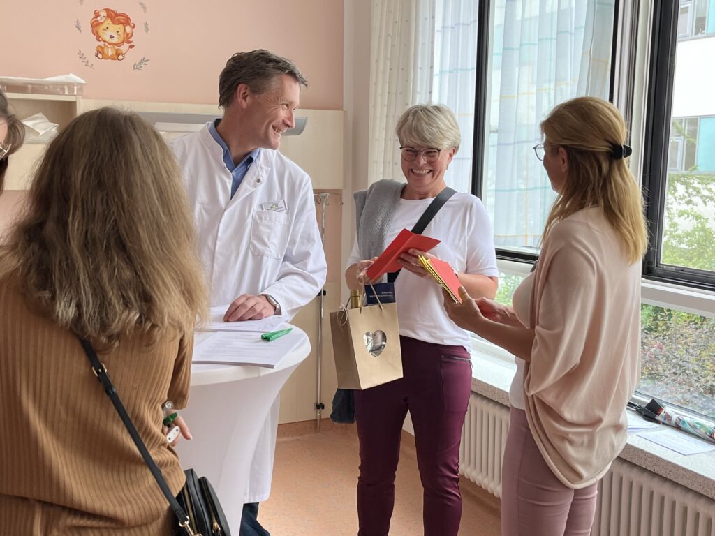 Ein kleines Präsent wird an eine Besucherin übergeben.