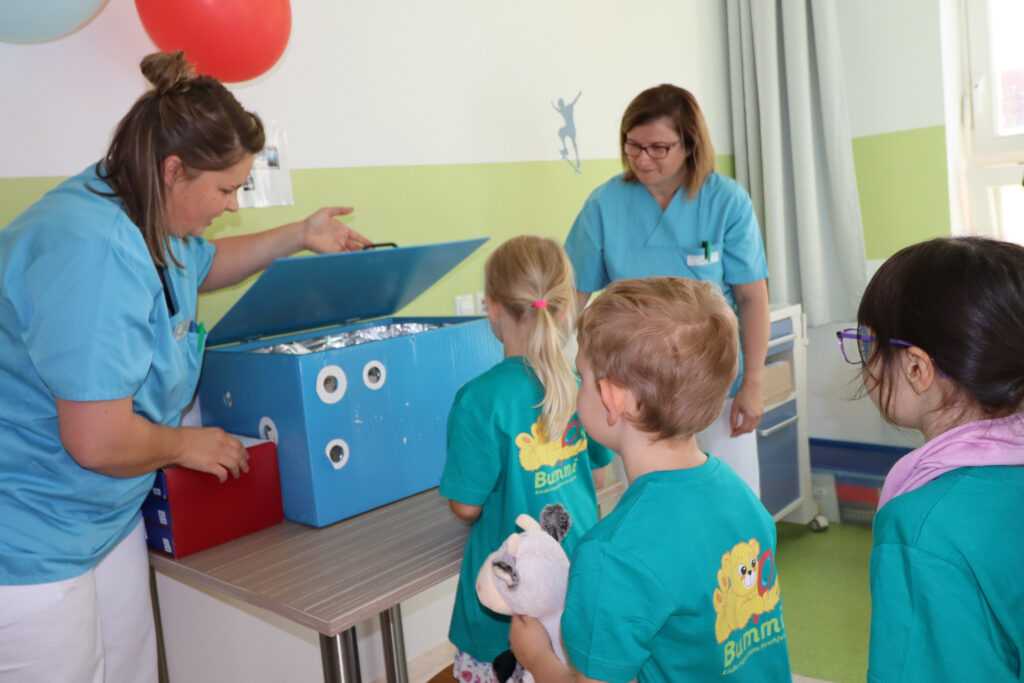 mehrere Kinder warten darauf mit ihrem Kuscheltier zum Teddyklinik-Röntgen zu können